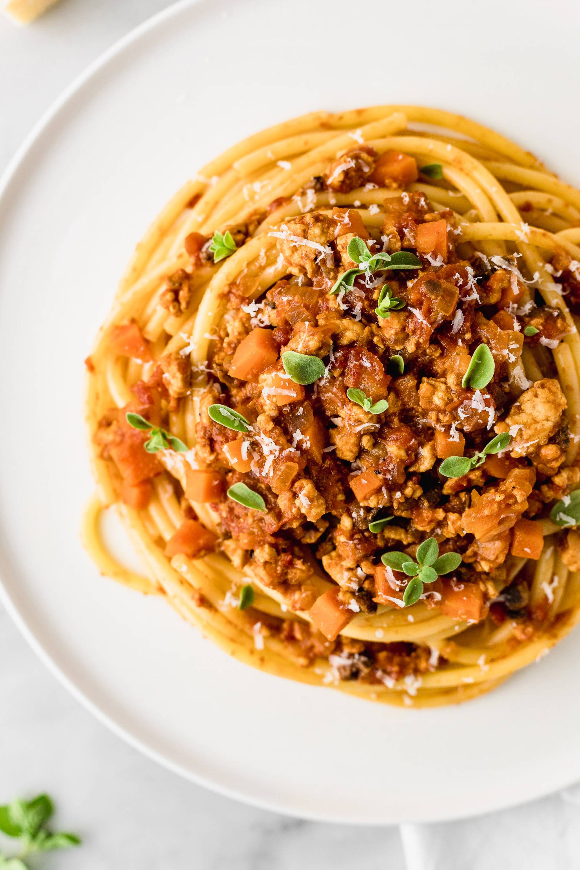 Pasta de espinaca en salsa marinara con carne molida de pavo servido con pan con ajo