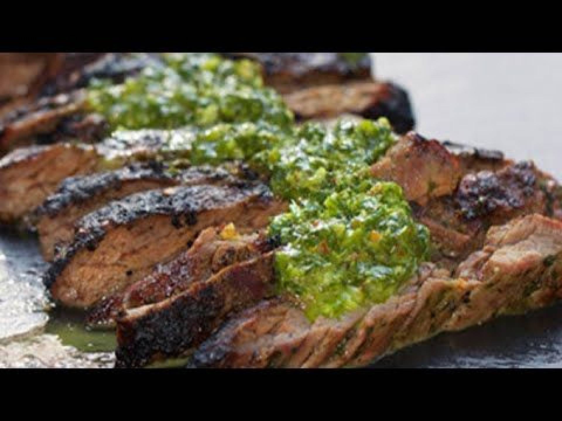 Tiras de res en salsa chimichurri servido con batatas horneadas