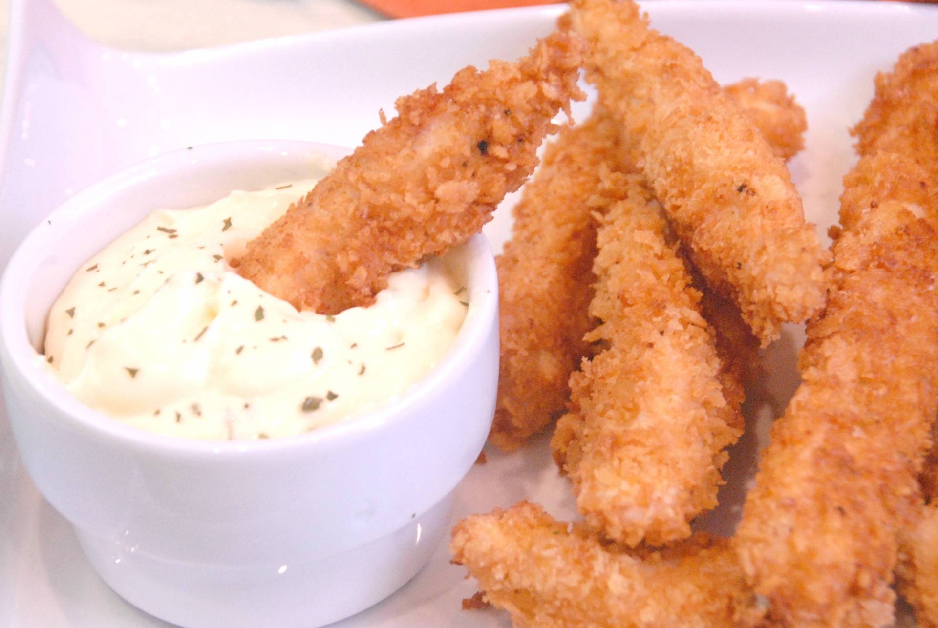 Chicken Fingers en harina de almendra con aioli de pepinillo servido con arroz verde