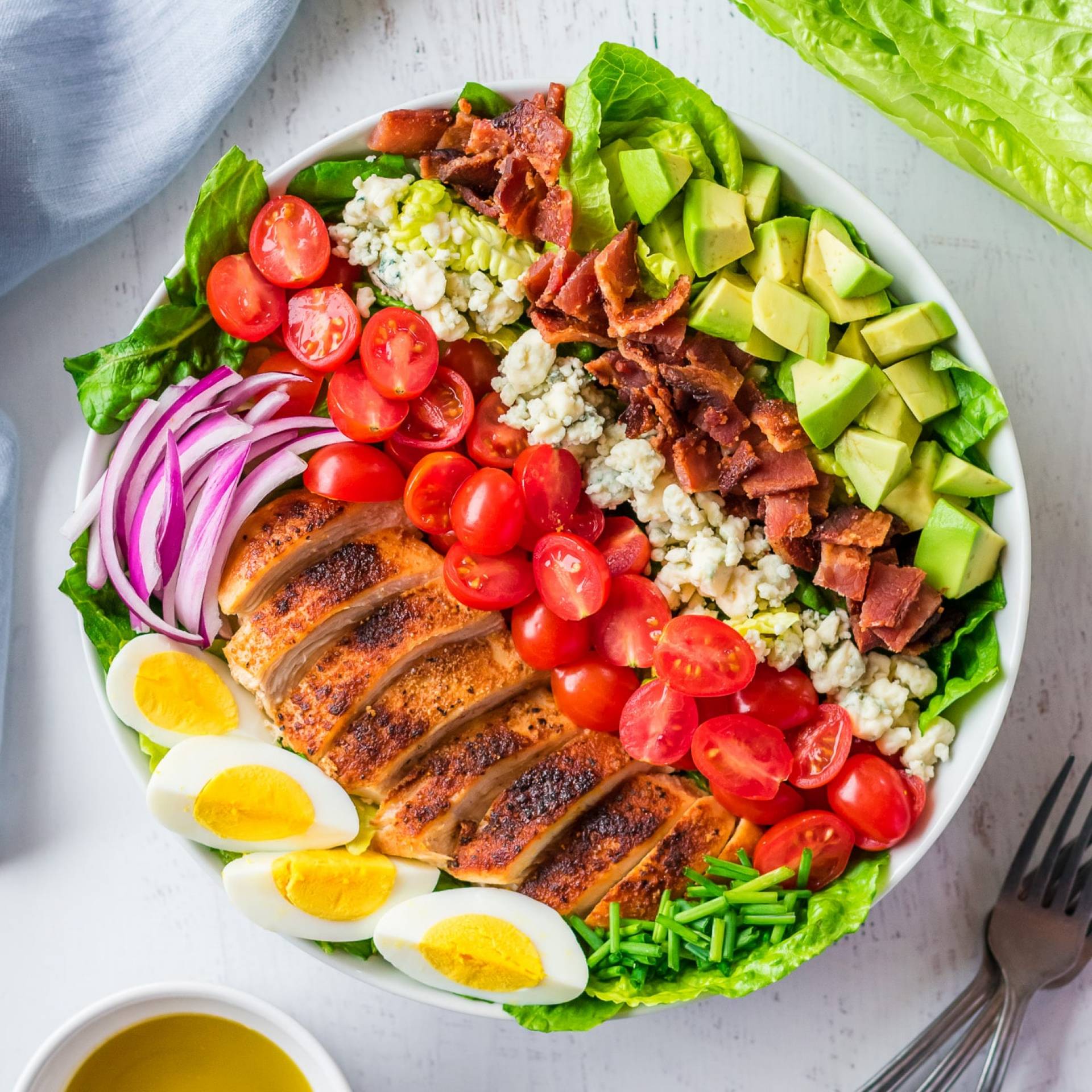 G. Cobb Salad: en cama de lechuga, tocineta, pollo, aguacate, huevo, cebolla lila, tomate, blue cheese con aderezo balsamico